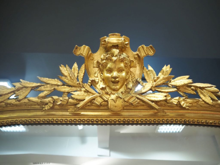 Rare paire de glaces Napoléon III en bois et stuc doré, à décor de feu