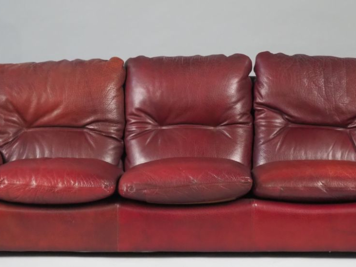 Canapé trois places garniture de cuir bordeaux (bon état).