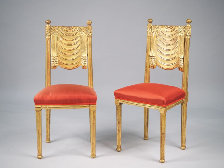 Paire de chaises de style Louis XVI en bois doré à décor de draperie e
