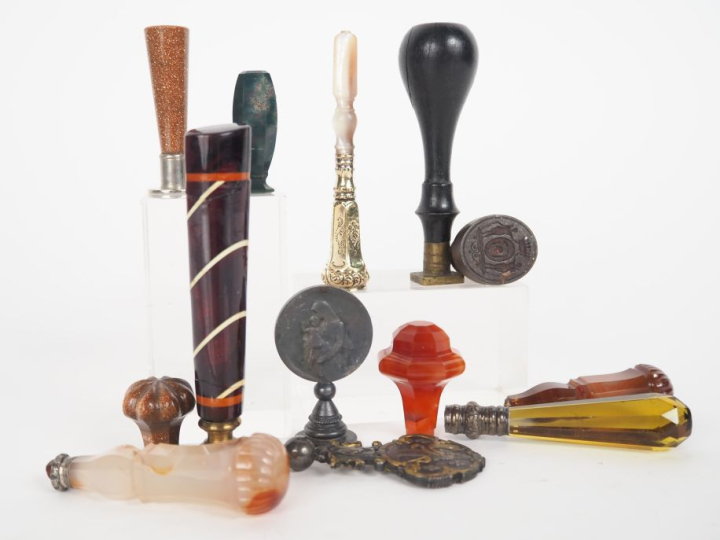 12 différents cachets en bois, verre, métal argenté ou doré. H. de 3 à