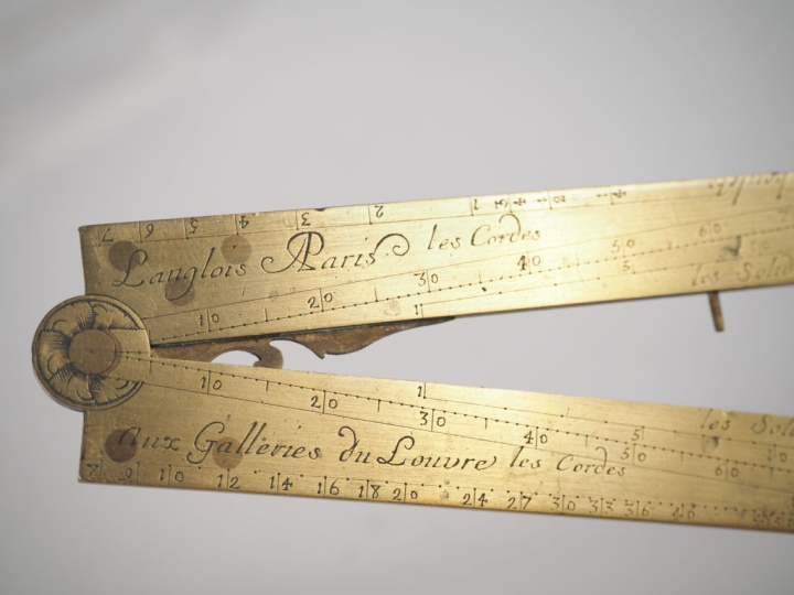 Compas de proportion en laiton, signé LANGLOIS à Paris. L. 33,5 cm.