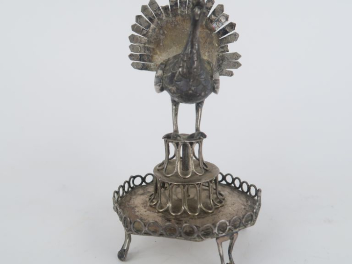 Baguier en métal argenté à décor ajouré et surmonté d'un paon. H. 12 c