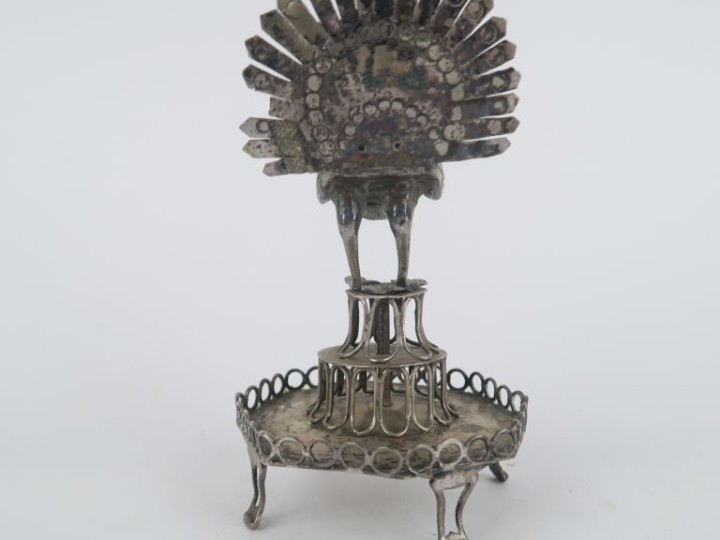 Baguier en métal argenté à décor ajouré et surmonté d'un paon. H. 12 c