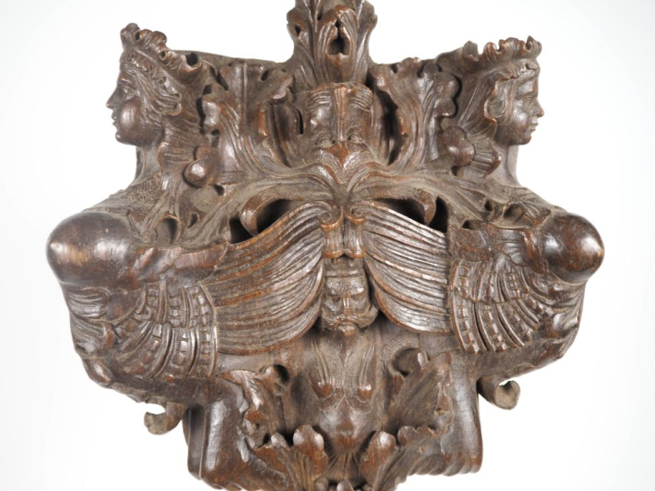 Plaque murale en bois sculpté à décor de bustes de chimères ailées. Di