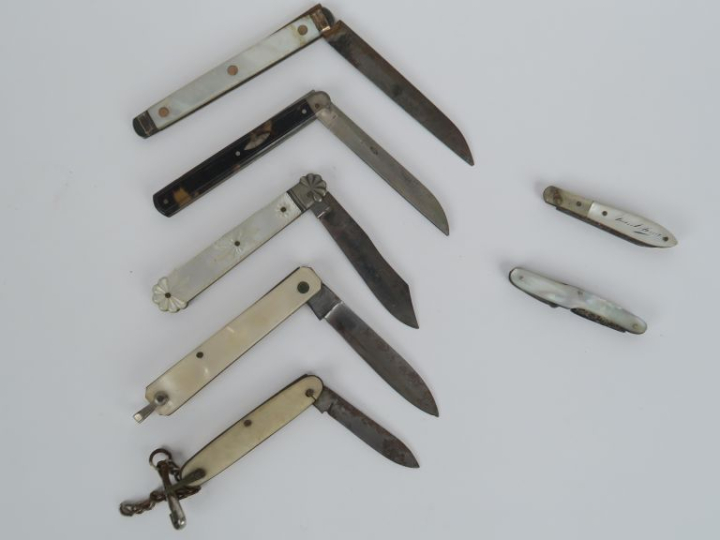 7 différents couteaux en métal et nacre. L. de 8 à 17,5 cm. (oxydation