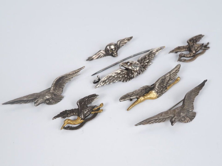 7 différentes broches en argent, métal argenté et doré à décor d'aigle