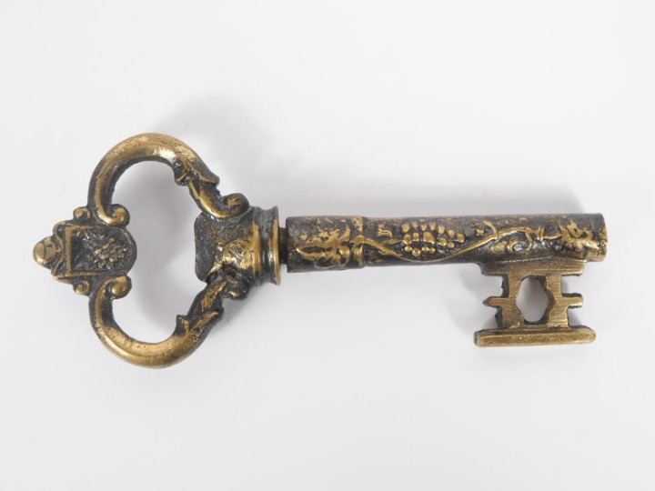 Tire bouchon en métal doré en forme de clé, à décor de pampres. Long. 