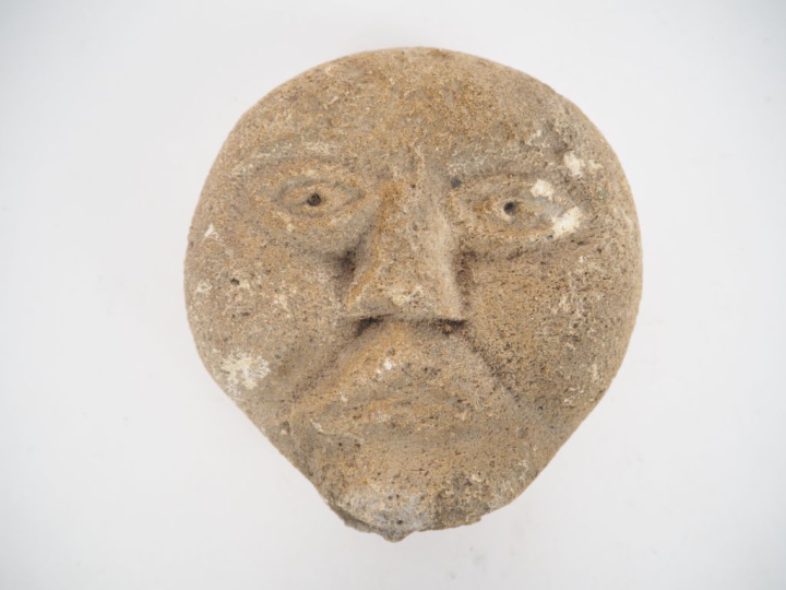 Tête masculine en pierre dans le style des ex-voto gallo romain. H. 12