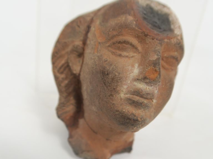 Tête d’Harpocrate en terre cuite avec sa mèche de cheveux caractéristi