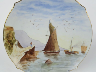Vente aux enchères Plat en porcelaine à décor peint à décor d'une marine. Diam. 33,5 cm.