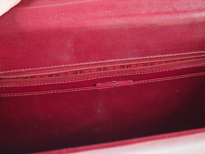 CARTIER Grande pochette en cuir bordeaux.  Fermeture à rabat et pressi