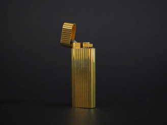 Vente aux enchères CARTIER, Paris Briquet de poche en plaqué or, à décor de cannelures.  