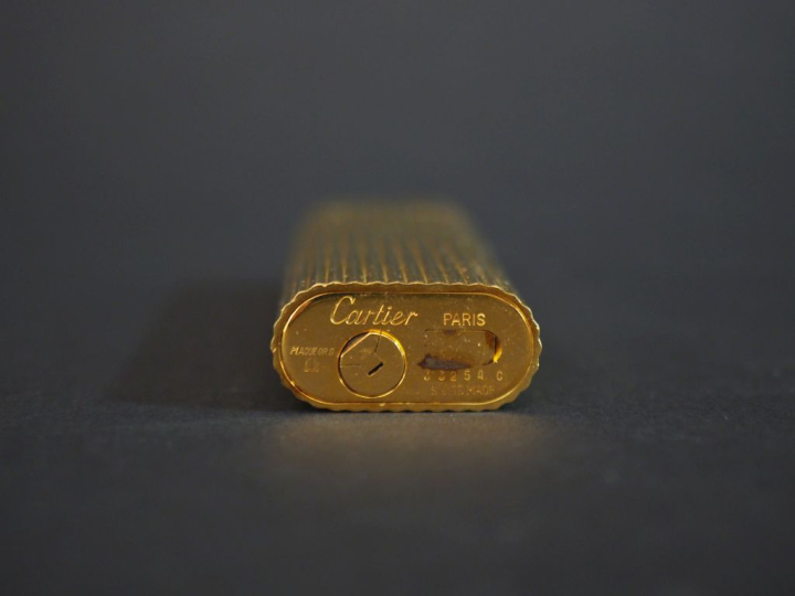 CARTIER, Paris Briquet de poche en plaqué or, à décor de cannelures.  