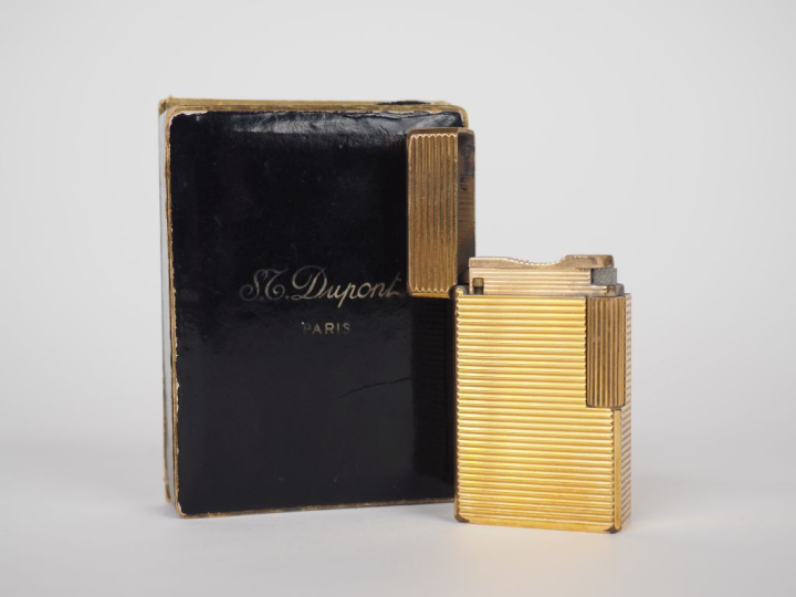 DUPONT Briquet en métal doré, à décor de cannelures.  Signé.  Dans sa 