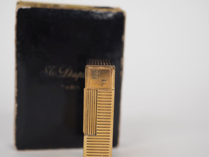 DUPONT Briquet en métal doré, à décor de cannelures.  Signé.  Dans sa 