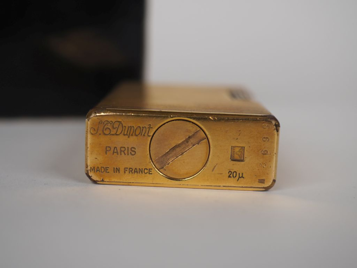 DUPONT Briquet en métal doré, à décor de cannelures.  Signé.  Dans sa 