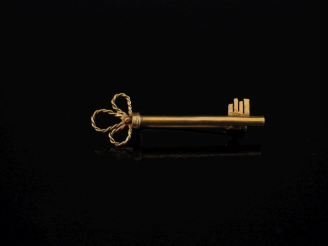 Vente aux enchères Broche barrette en or jaune 750, en forme de clé.  Long. 4,2 cm Poids.