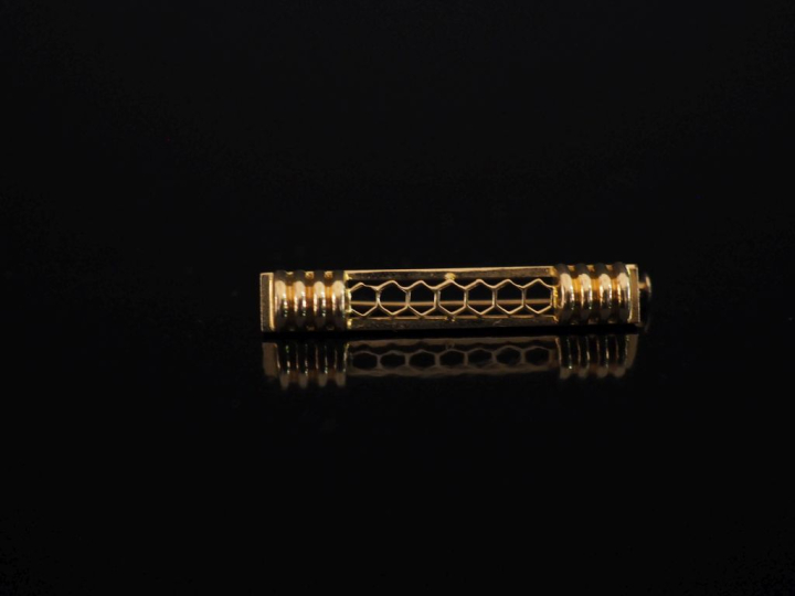 Petite broche barrette en or jaune 750, à décor ajouré agrémenté de pa