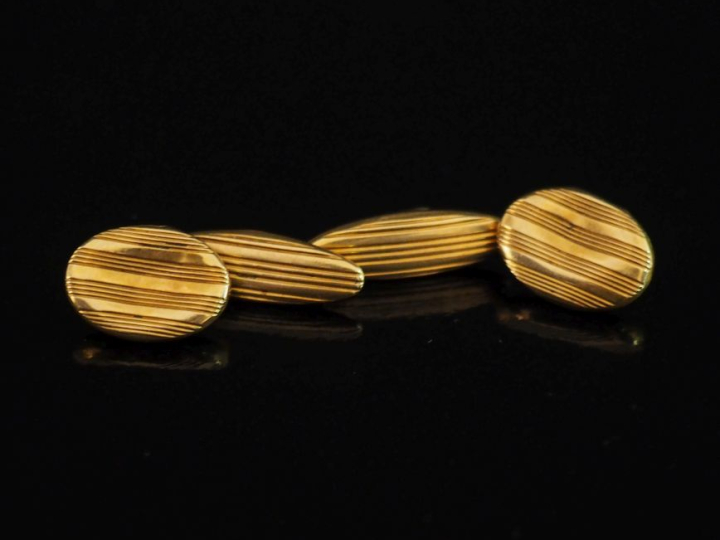 Paire de boutons de manchettes en or jaune 750, à décor de stries.  Po