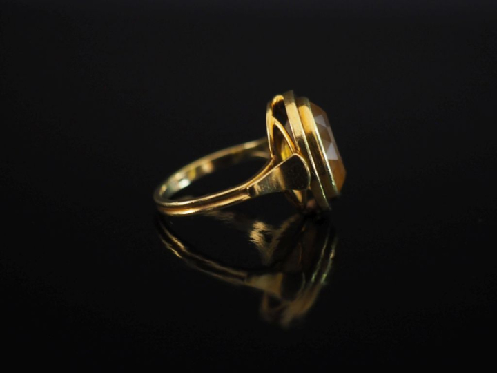 Bague en or jaune 750, sertie en son centre d'une citrine.  Jolie mont