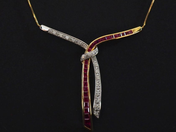 Collier deux tons d'or 750, à décor de nœud de ruban serti de rubis ca