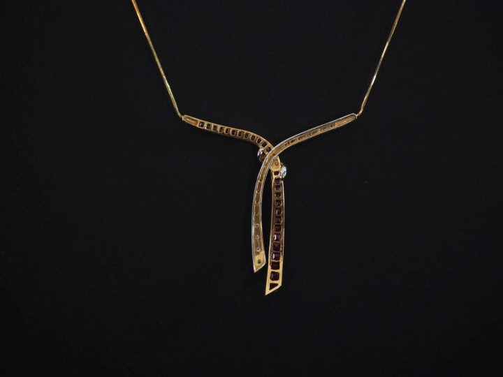 Collier deux tons d'or 750, à décor de nœud de ruban serti de rubis ca