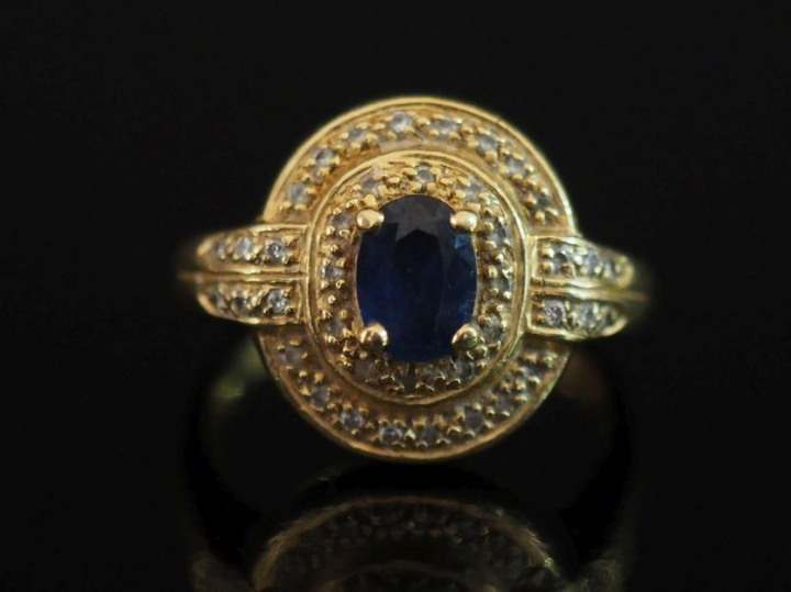 Bague en or jaune 750, sertie en son centre d'un saphir agrémenté de d
