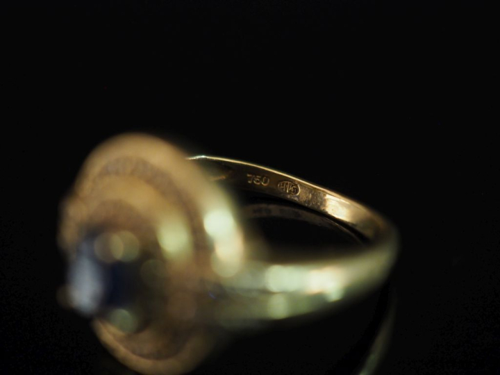 Bague en or jaune 750, sertie en son centre d'un saphir agrémenté de d