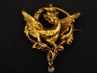 Vente aux enchères Broche ajourée en or jaune 750, à décor d'une chimère et agrémentée d'