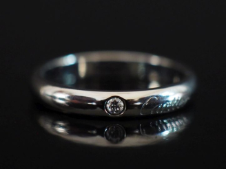 Vente aux enchères CARTIER Bague jonc en or 750 et platine 950, sertie en son centre d'un