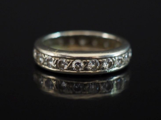 Vente aux enchères Alliance américaine en or blanc 750, sertie de petits diamants.  TDD. 
