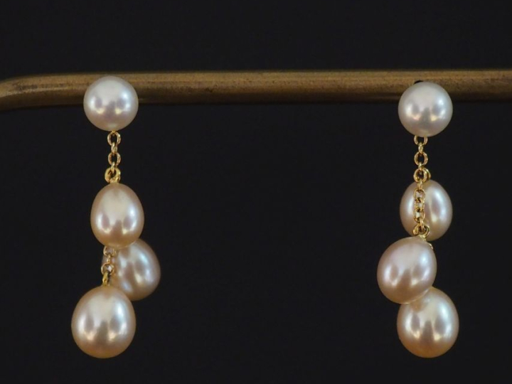 Paire de perces oreilles en or jaune 750, sertis d'une perle et de tro