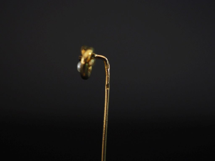 Epingle à cravate en or jaune 750, à décor d'entrelacs et sertie d'une