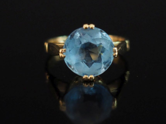 Vente aux enchères Bague en or jaune 750, sertie en son centre d'une pierre bleu ciel.  T