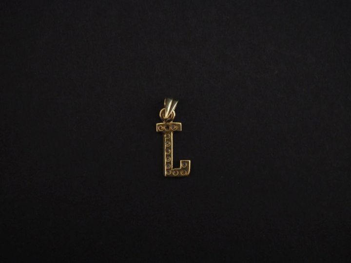 Pendentif en or jaune 750, en forme de "J" et serti de petits diamants