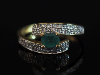 Vente aux enchères Bague de forme stylisée en or jaune 750, sertie en son centre d'une ém