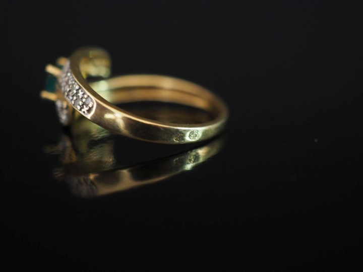 Bague de forme stylisée en or jaune 750, sertie en son centre d'une ém