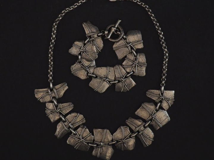 Demi parure en métal argenté ou argent bas-titre, à décor de motifs ab