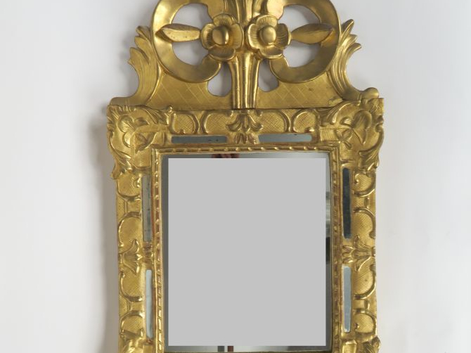 Miroir Louis XV en bois sculpté et doré, à décor de fleurons et de rin