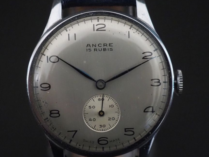 Montre bracelet Swiss made en acier.  Cadran rond à chiffres arabes po