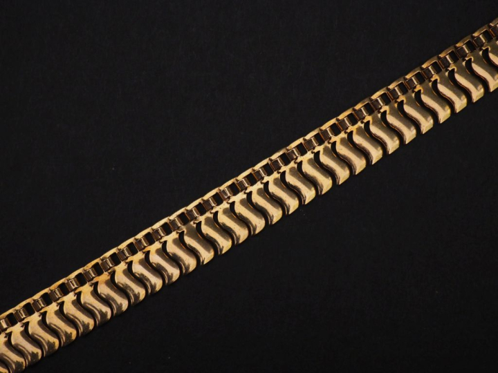 Collier souple en or jaune 750, à décor de vaguelettes.  Larg. 1,2 cm 