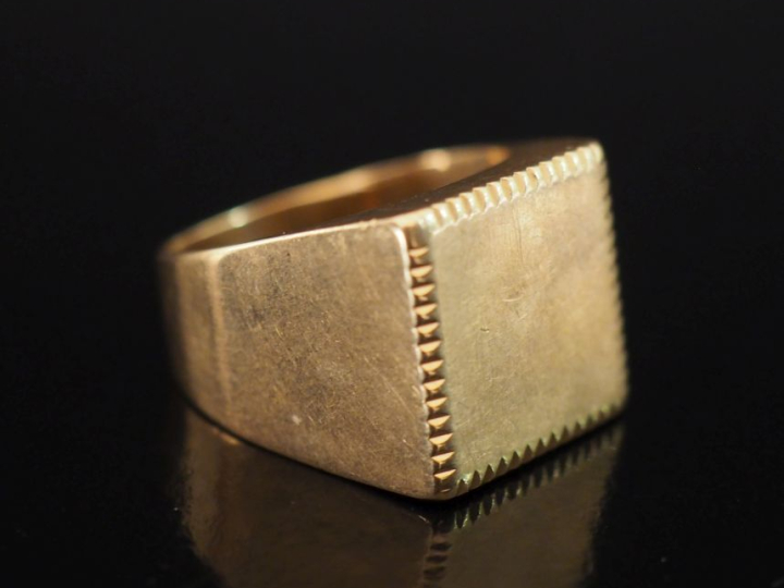 Bague de forme chevalière en or jaune 750.  Le pourtour du plateau, à 