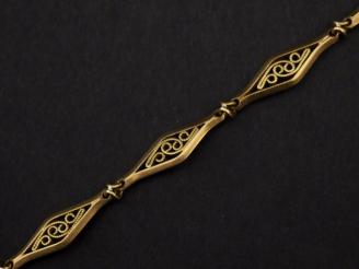 Vente aux enchères Giletière en or jaune 750, composée de maillons ajourés à décor filigr