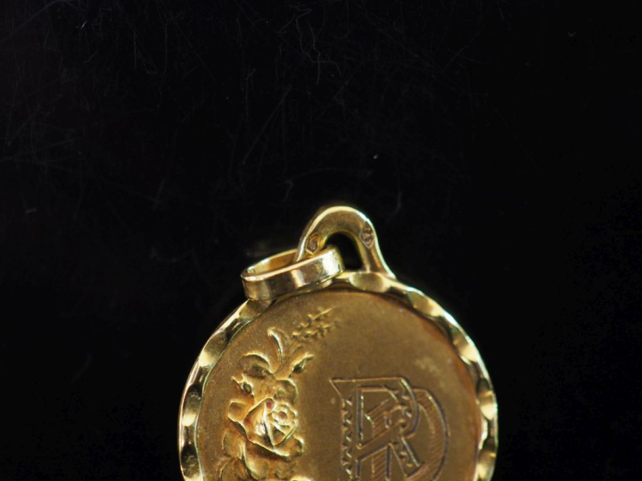 Médaille en or jaune 750, à décor gravé de monogramme et agrémenté de 