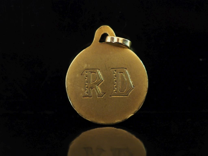 Médaille en or jaune 750, à décor gravé de monogramme et agrémenté de 