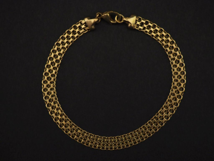 Bracelet souple en or jaune 750, maille plate tressée et ajourée.  Lon