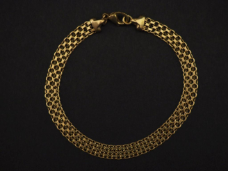 Vente aux enchères Bracelet souple en or jaune 750, maille plate tressée et ajourée.  Lon
