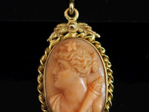 Pendentif ovale en or jaune 750, serti en son centre d'un camée corail