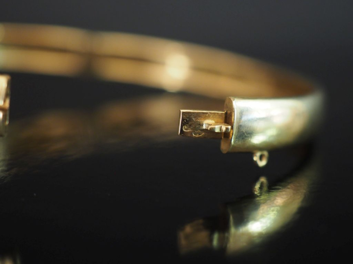 Bracelet jonc en or jaune 750 et argent, à décor en son centre d'un mo