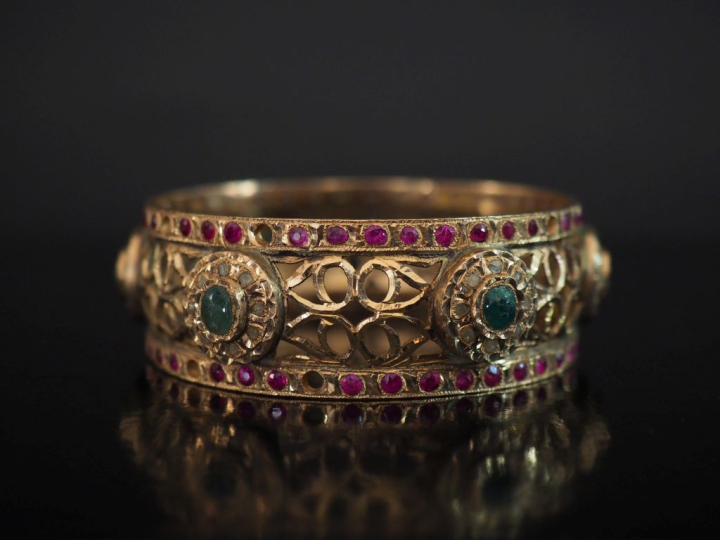 Bracelet jonc en or jaune 750, à décor ajouré agrémenté de six médaill